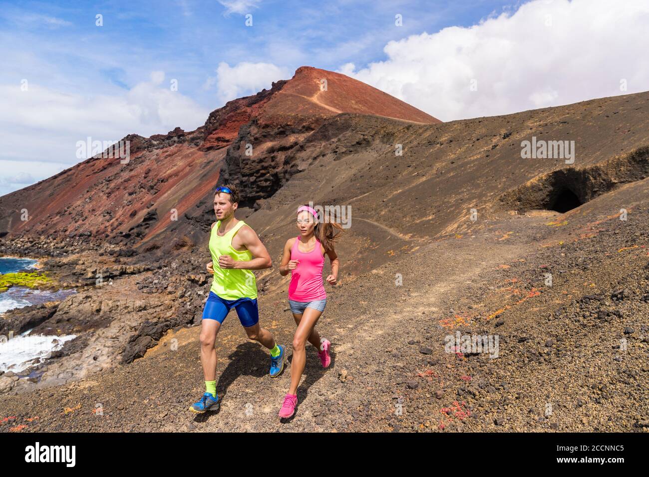 Allenamento di coppia dei corridori del sentiero di corsa in montagna. Ultra run atleti di gara allenarsi insieme su montagne vulcaniche paesaggio naturale in estate all'aperto Foto Stock