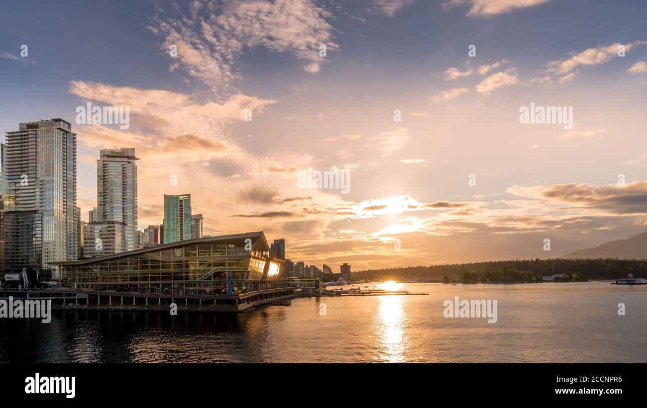 Tramonto sul Terminal degli idrovolanti e sull'alto Condominio Torri nel quartiere di Coal Harbour sulla riva di Porto di Vancouver Foto Stock