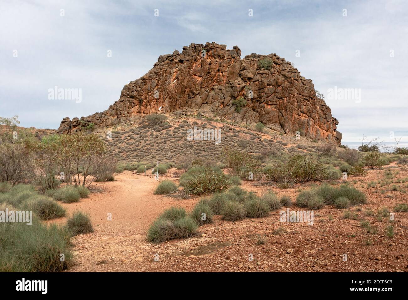 Corroboree rock: Sacro rock aborigeno australiano, vicino ad Alice Springs. Formazione verticale piatta, colori arancio. West Macdonnell Ranges, Australia Foto Stock