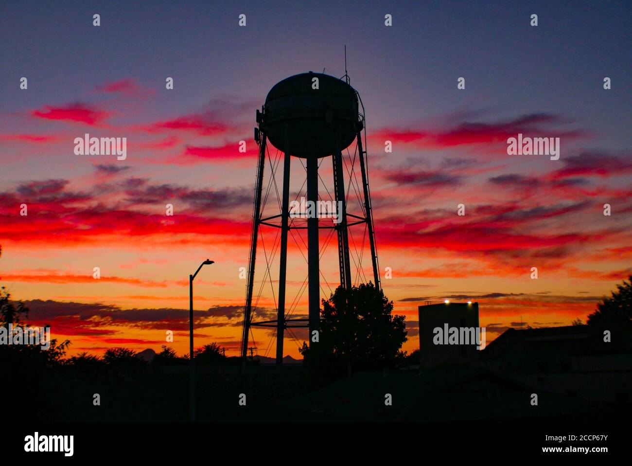 Nuvole colorate al tramonto dietro una silhouette di un serbatoio d'acqua A Yuba City, California Foto Stock