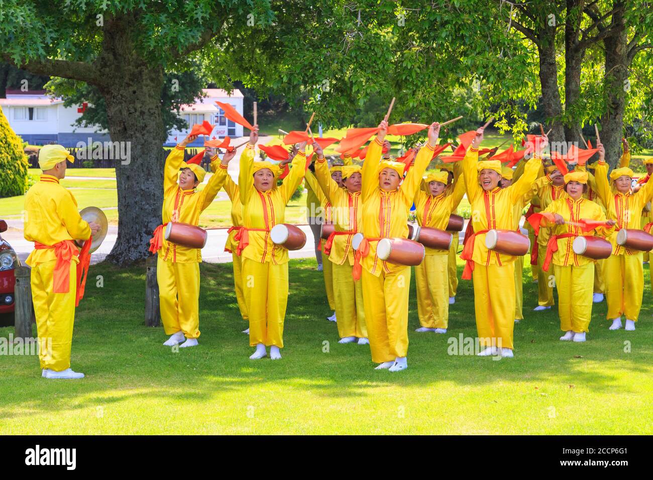 Membri di Falun Dafa, aka Falun Gong, un movimento religioso cinese, che pratica una danza con sciarpe e tamburi della vita. Rotorua, Nuova Zelanda, 12/8/2018 Foto Stock