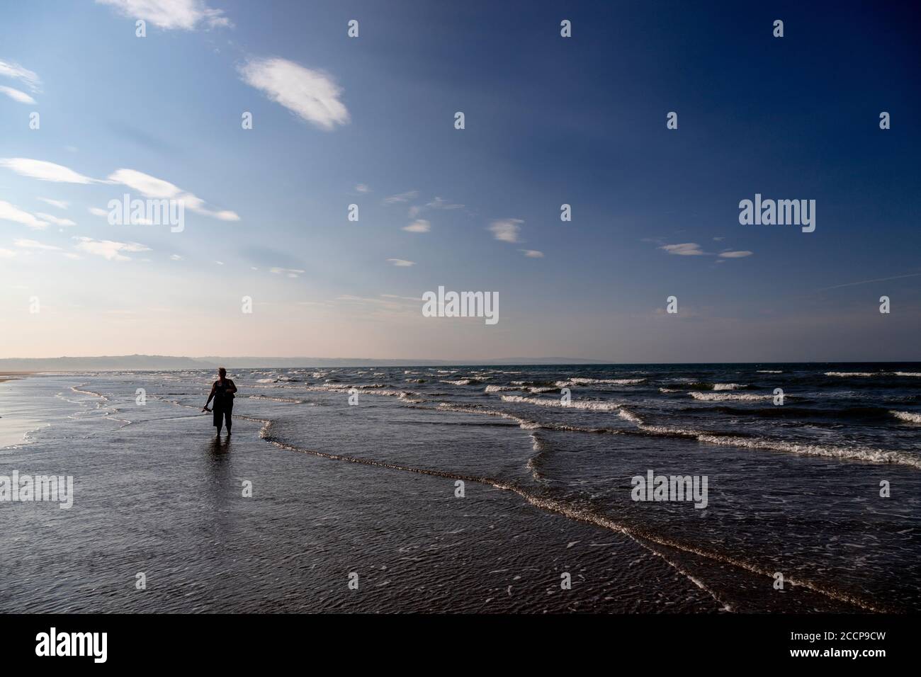 Donna che si addormentava a Llanddona Beach, Anglesey, Galles del Nord Foto Stock