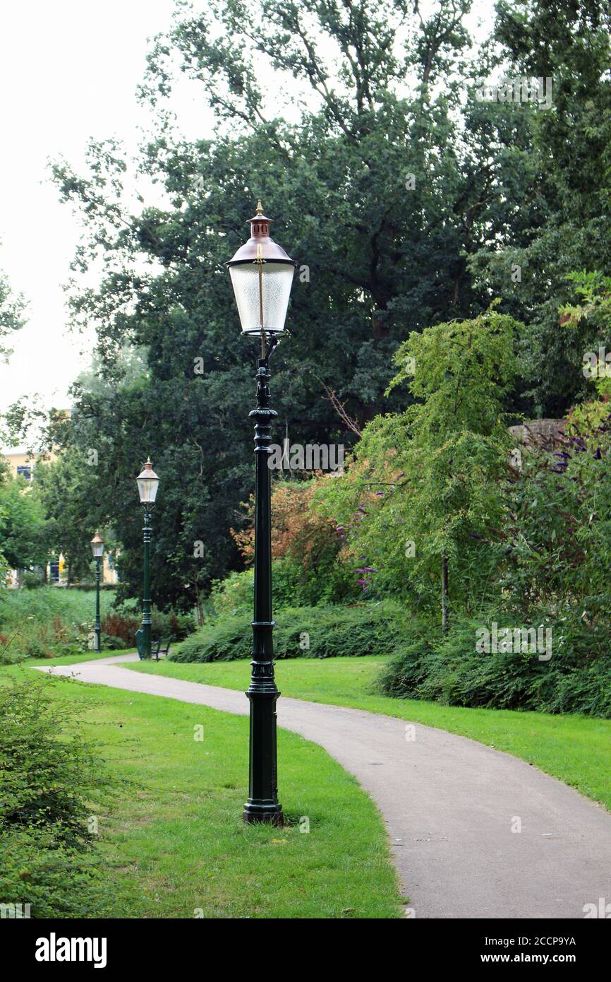 Fila di vecchi pali di lanterna in un parco nel Paesi Bassi Foto Stock