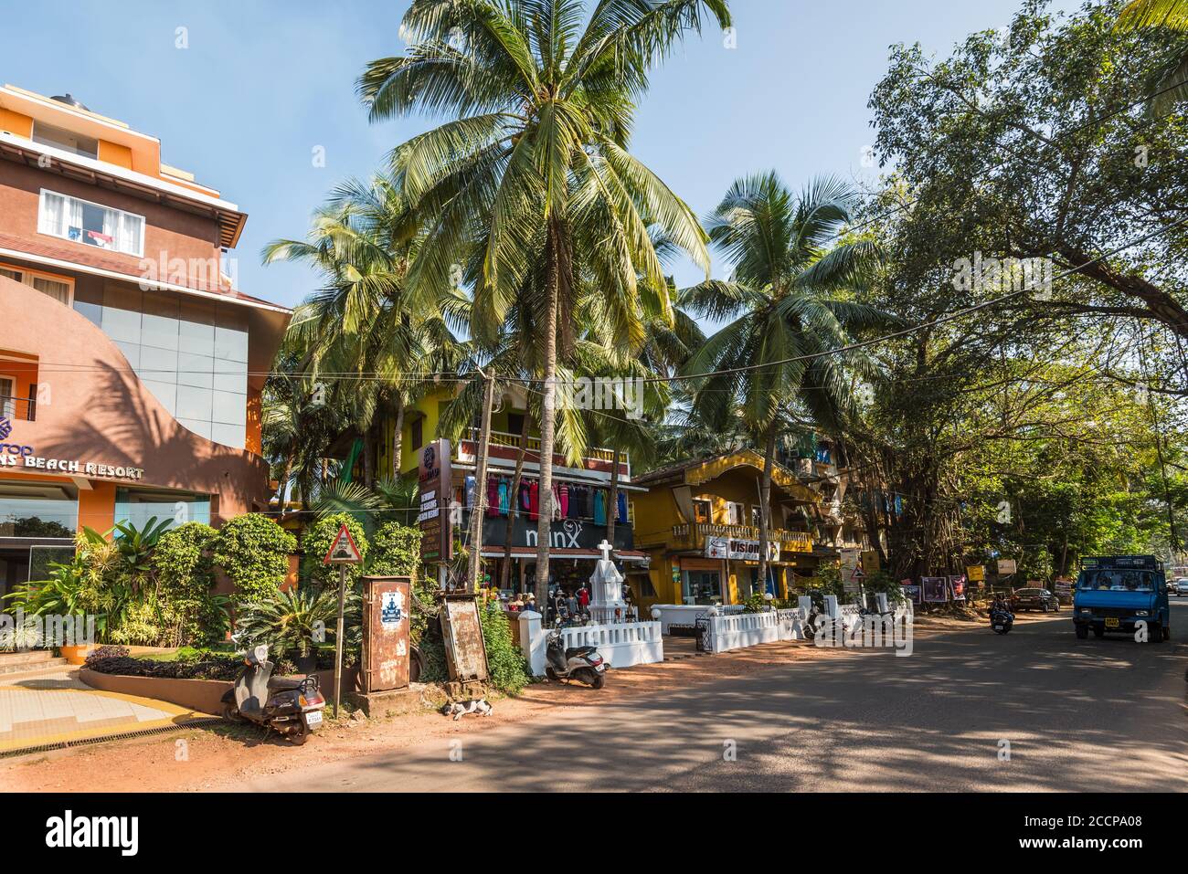 Candolim, Nord Goa, India - 23 novembre 2019: Vista di strada di Goa in giornata di sole con biciclette parcheggiate vicino negozi turistici e farmacia a Candolim, Nord G Foto Stock