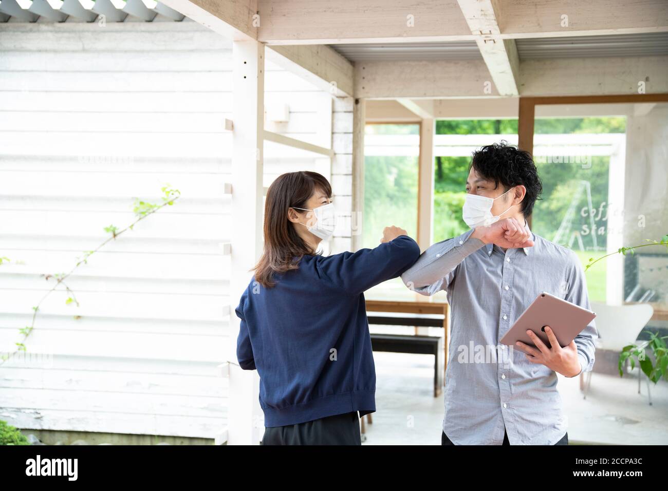L'uomo e la donna stanno facendo un saluto di urto del gomito senza Toccare le mani Foto Stock