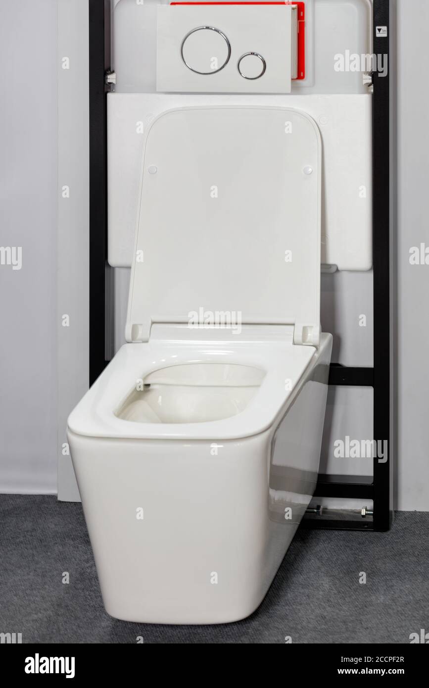 Recipiente per wc bianco con moderno sistema appeso a parete e meccanismo a filo. Foto Stock