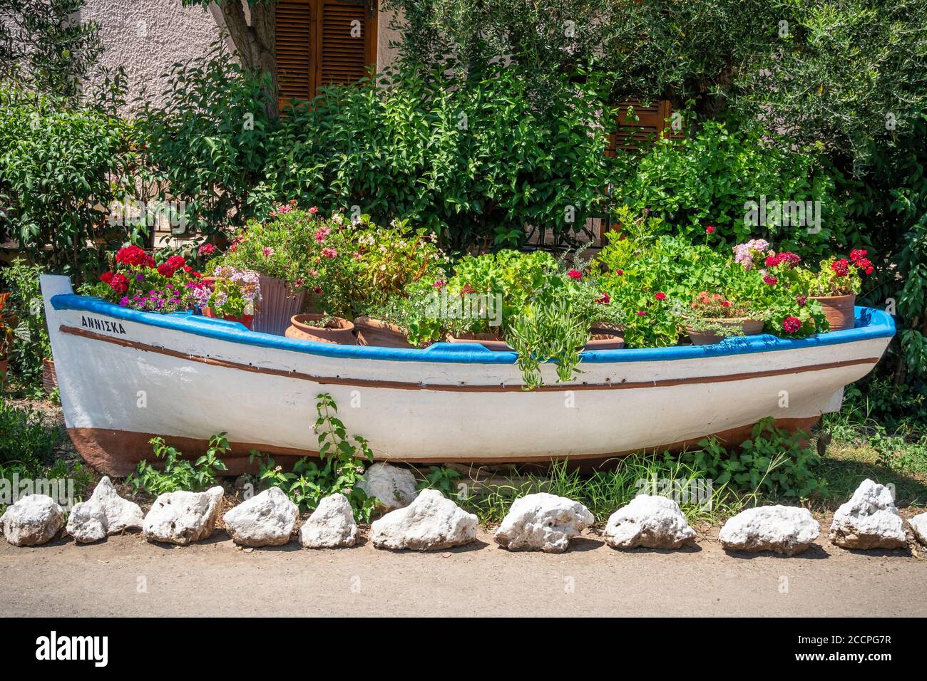 Una vecchia barca a remi riutilizzata come contenitore per le piante, nel villaggio di Kardamyli, nel mani, Peloponneso, Grecia. Foto Stock