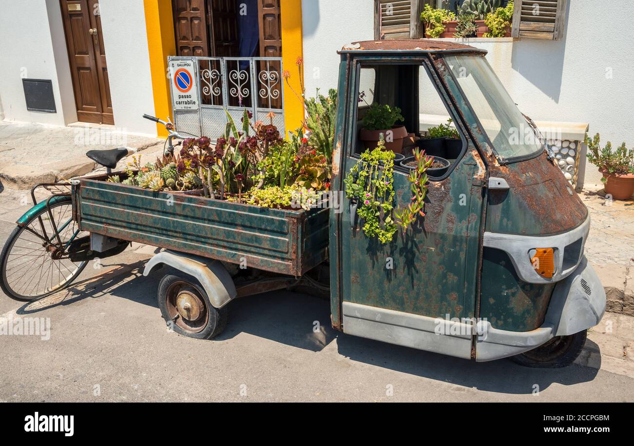 Un vecchio pickup a tre ruote Piaggio, riutilizzato come contenitore per impianti nella città di Gallipoli, Puglia meridionale, Italia. Foto Stock