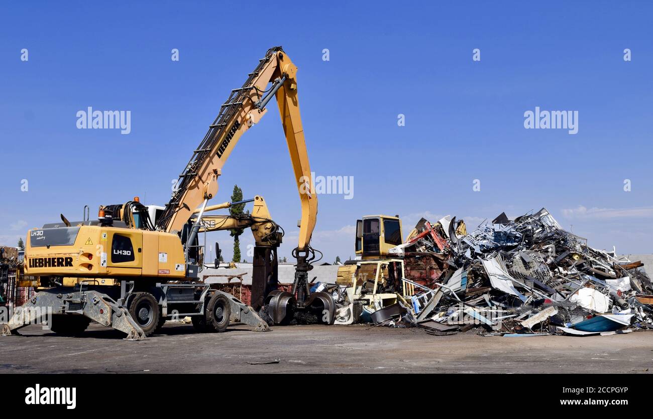 FRESNO, STATI UNITI - 12 agosto 2020: Centro di riciclaggio Fresno,CA durante il giorno con un cielo blu luminoso sfondo con grande macchina operatrice pesante p Foto Stock