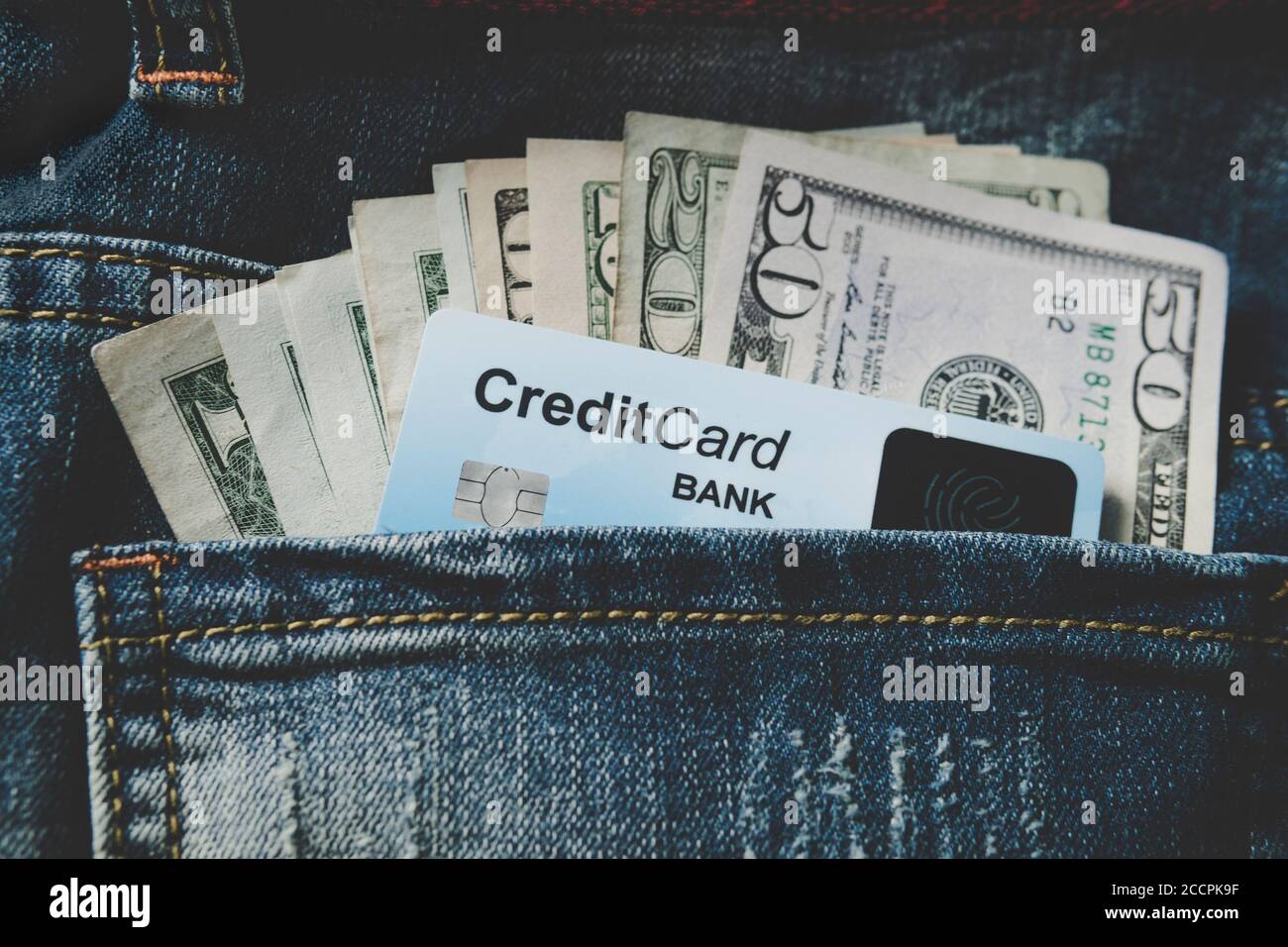 Dollari USA e credito, carta di debito primo piano nella tasca posteriore jeans Foto Stock