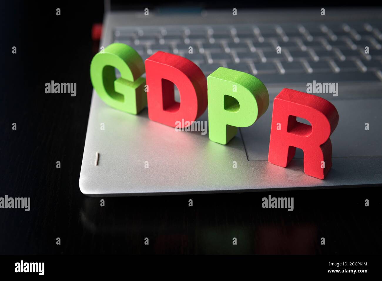 Regolamento generale sulla protezione dei dati - lettere in legno del GDPR disposte sulla parte inferiore del computer portatile su sfondo nero. Concetto di protezione dei dati. Privacy in internet Foto Stock