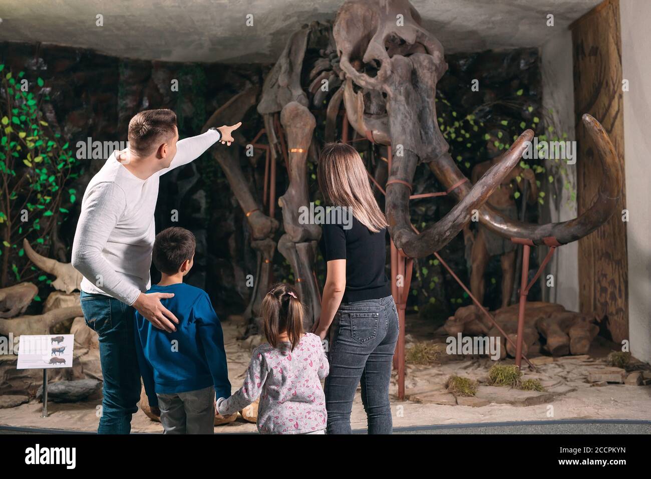 Famiglia nel Museo. Una famiglia si trova di fronte ad uno scheletro di mammut nel Museo di paleontologia. Foto Stock