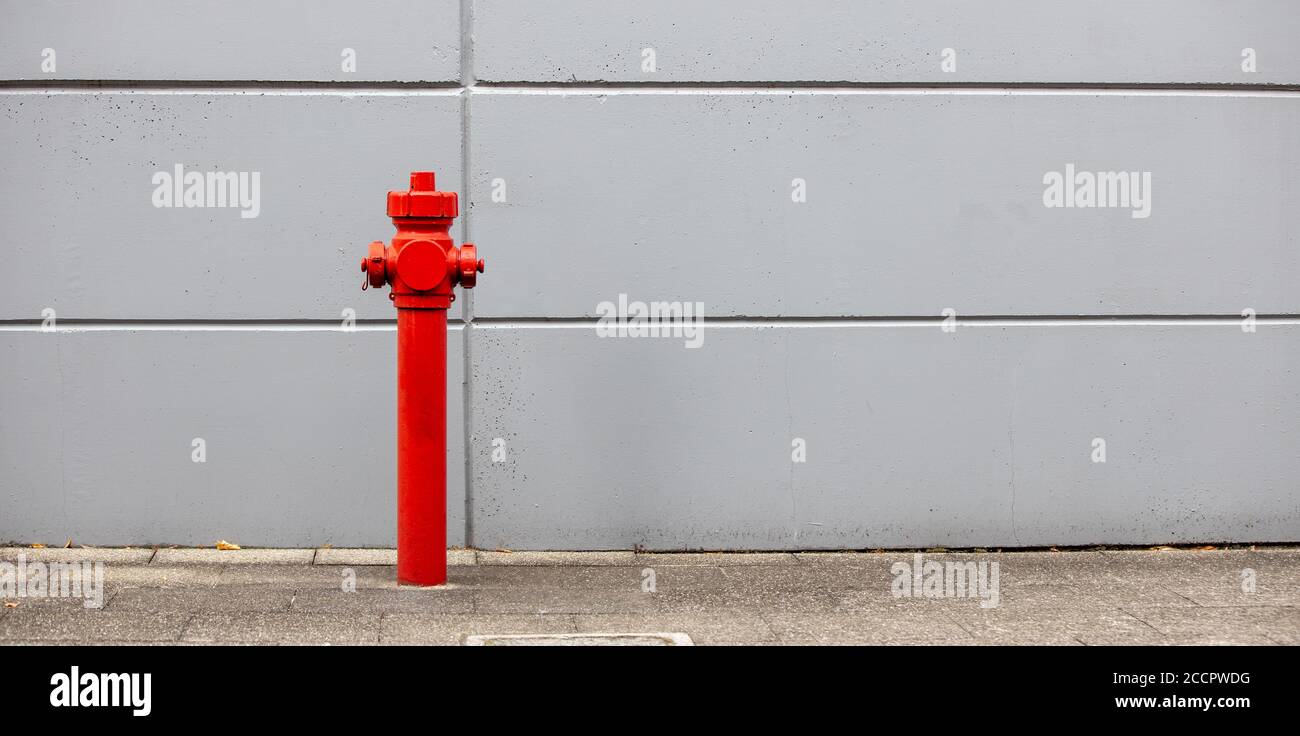 idrante rosso, impianto antincendio con parete grigia, panorama Foto Stock