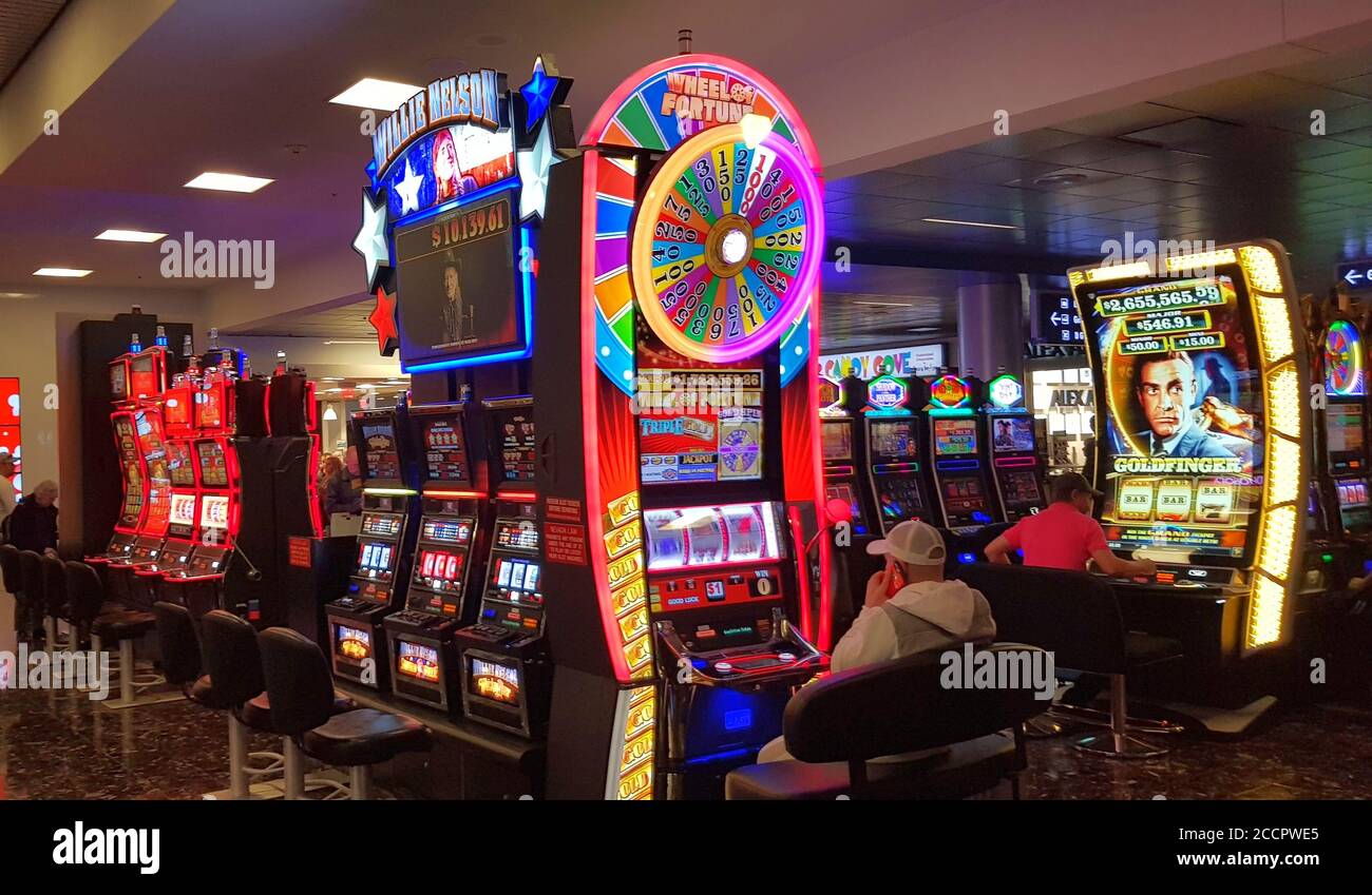 Un uomo gioca slot machine presso l'aeroporto internazionale McCarran, Las Vegas Nevada, Stati Uniti Foto Stock