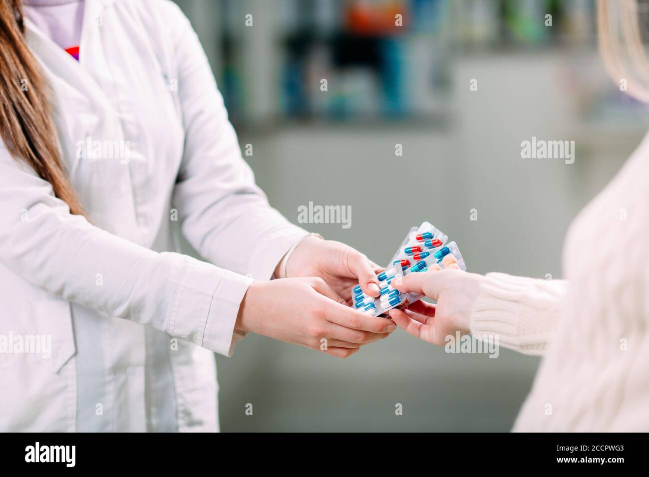 Primo piano di una ragazza mani acquistare pillole in una farmacia. Foto Stock