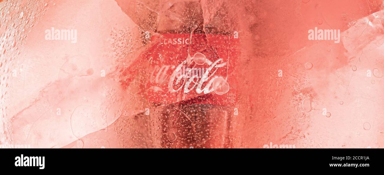 Krasnoyarsk, Russia, 16 agosto 2020: Ghiaccio, con una bottiglia surgelata di Coca Cola. Sfondo rossastro, foto panoramica Foto Stock
