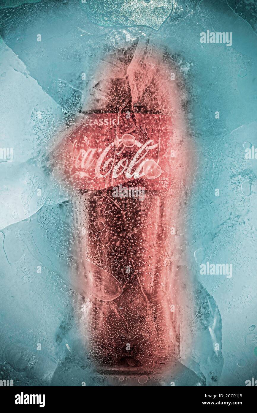 Krasnoyarsk, Russia, 16 agosto 2020: Una bottiglia di Coca Cola congelata in un blocco di ghiaccio. Sfondo verdastro Foto Stock