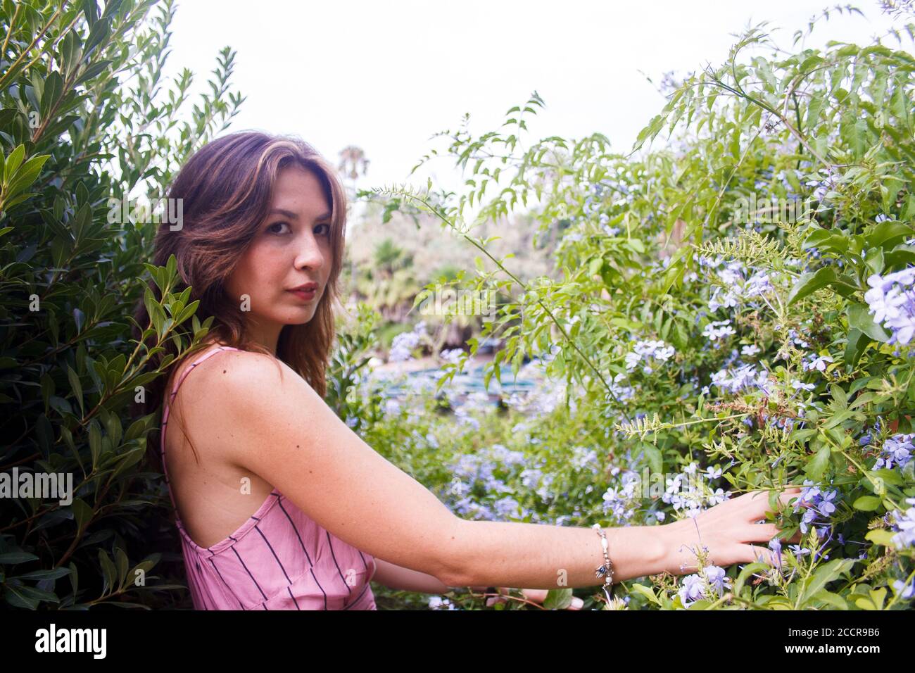 Giovane donna esplorando intorno al lago locale e scendendo lungo un sentiero frondoso. Scatto medio. Vista orizzontale. Foto Stock