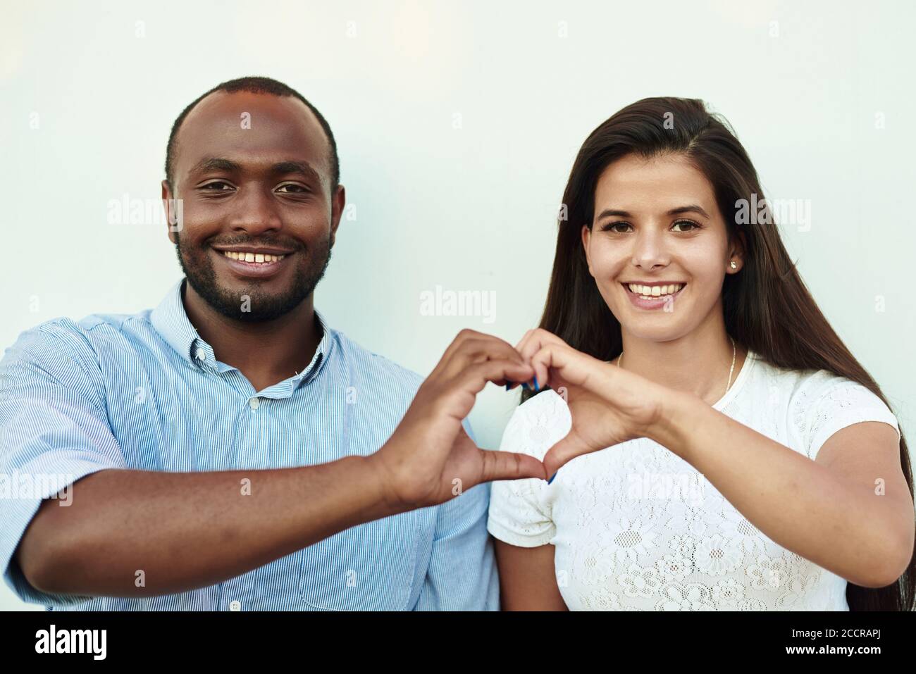 La coppia nera sta mostrando un cuore. L'uomo e la donna stanno facendo il cuore con le dita. Foto Stock