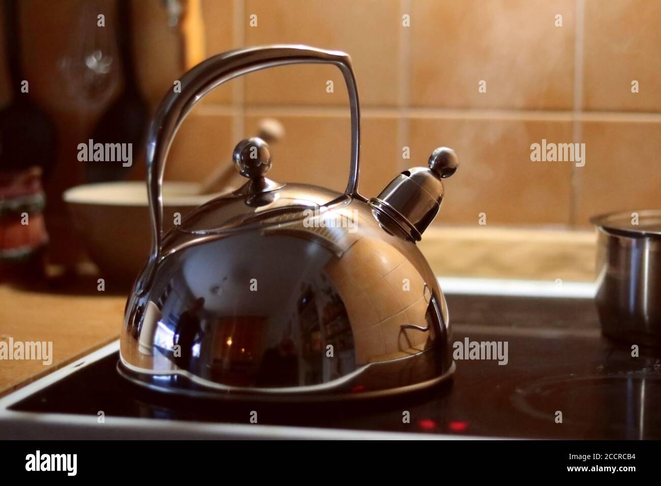 Bollitore d'acciaio sul forno in cucina, acqua bollente Foto Stock