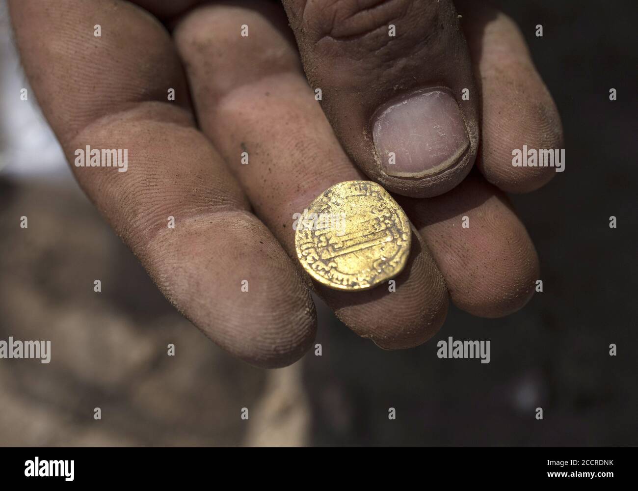 Israele centrale, Israele. 24 Agosto 2020. L'archeologo israeliano Shahar Krisin detiene una moneta d'oro trovata in un tesoro di 423 monete d'oro risalenti alla dinastia abbaside è stato scoperto in un sito archeologico nel centro di Israele martedì 18 agosto 2020. Gli scavi sono stati effettuati dall'autorità israeliana delle Antichità in un'area che un tempo era un'area industriale durante il periodo bizantino . Si dice che le monete abbiano 1200 anni . Foto piscina di Heidi Levine/UPI Credit: UPI/Alamy Live News Foto Stock