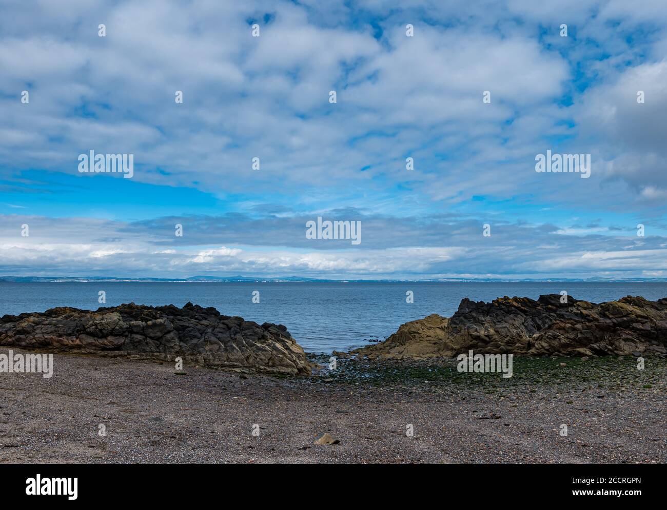 Vista da Firth of Forth a Fife dalla piccola baia a bassa marea, Cockenzie, East Lothian, Scozia, Regno Unito Foto Stock