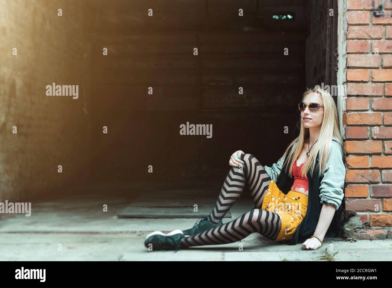 Giovane donna hipster che si rilassa in un ambiente urbano Foto Stock