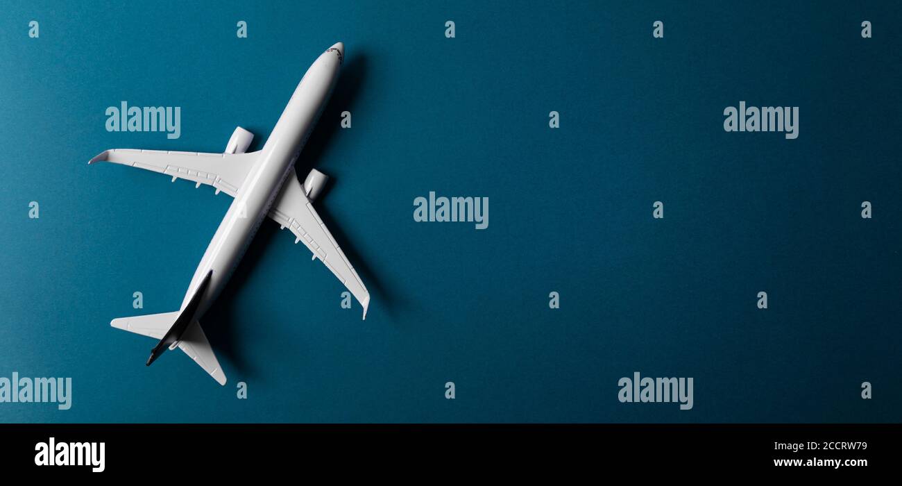 modello di aeroplano bianco su sfondo di carta blu con banner spazio di copia. vista dall'alto Foto Stock
