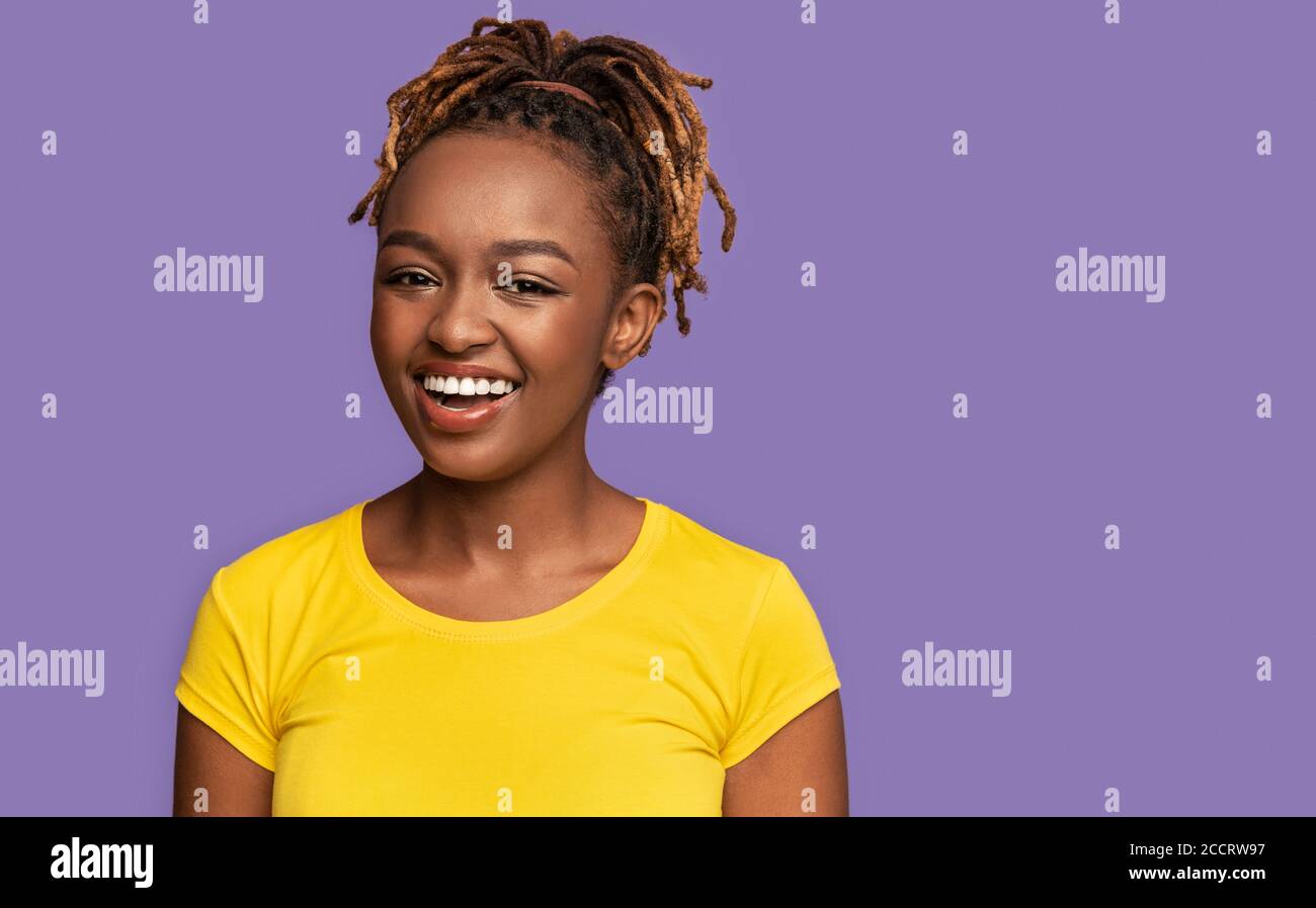 Ridendo afroamericana ragazza su sfondo viola Foto Stock