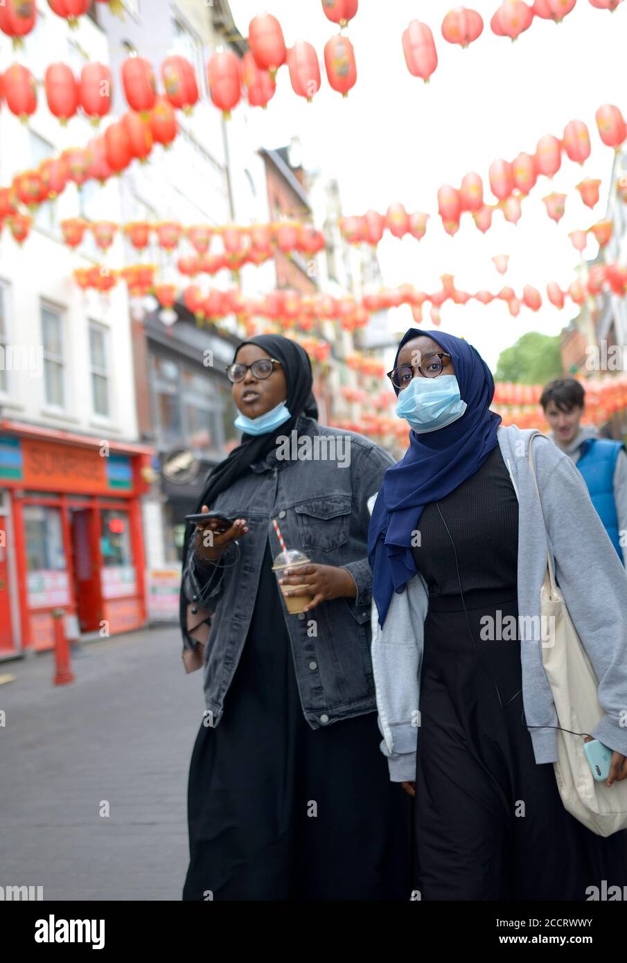 Londra, Inghilterra, Regno Unito. Giovani donne musulmane a Chinatown che indossano maschere facciali durante la pandemia di COVID, agosto 2020 Foto Stock