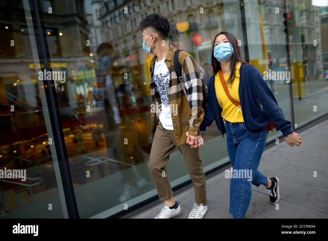 Londra, Inghilterra, Regno Unito. Giovane coppia asiatica che indossa maschere per il viso durante la pandemia COVID, agosto 2020 Foto Stock