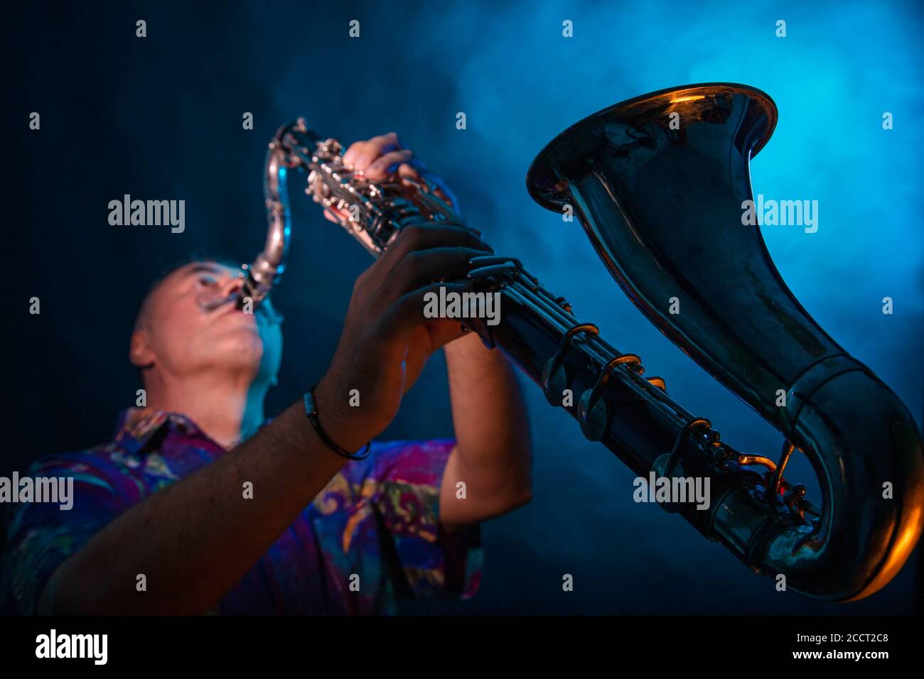 Un uomo suona il clarinetto basso grande. Studio, sfondo scuro. Foto di alta qualità Foto Stock