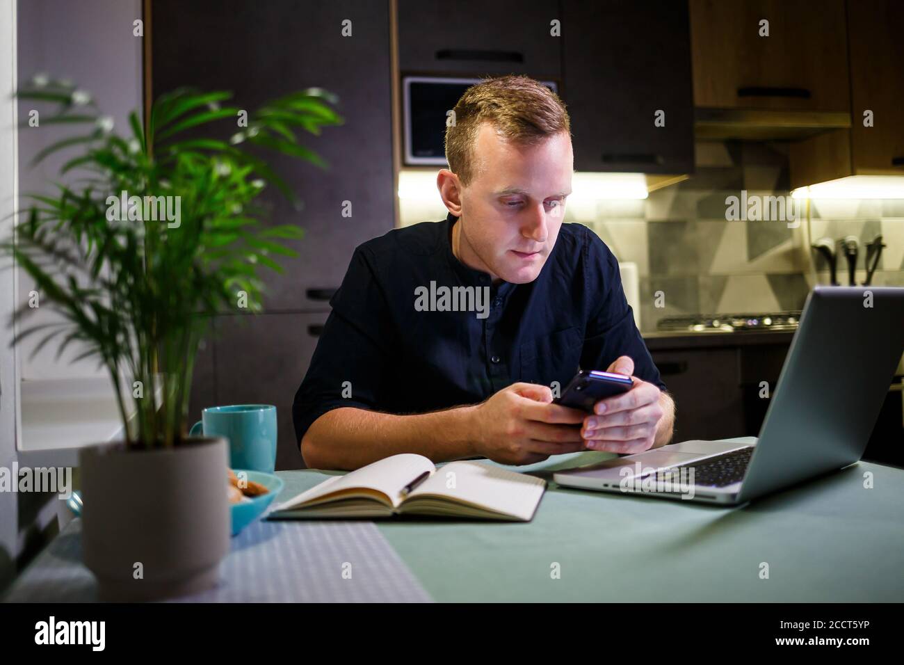 uomo d'affari che lavora con il laptop, lavoro da casa, pensieroso e preoccupato per il futuro, parlando al telefono, le tendenze del mercato azionario, messaggi, virus q Foto Stock