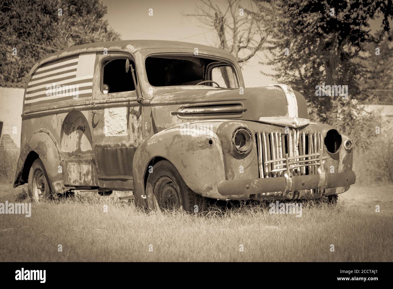 Il vecchio van americano deserted arrugginisce via il seppia toned riflette è l'età e la condizione. Foto Stock