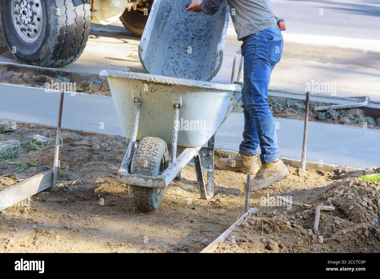 Carriola con pala piena di cemento di betoniera in macchina impastatrice per  calcestruzzo in operaio industriale Foto stock - Alamy