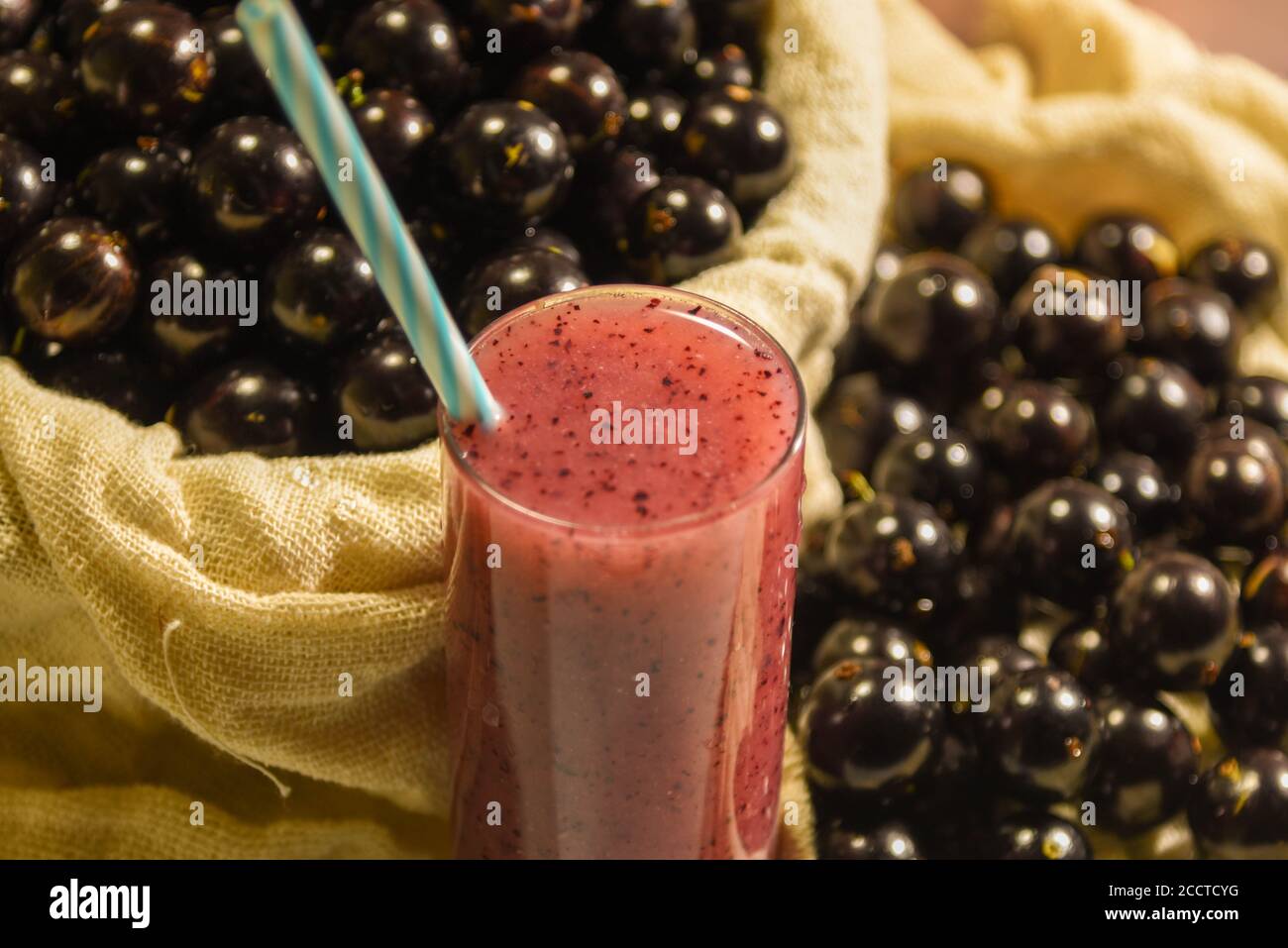 Frutta fresca e bicchiere di succo di jaboticaba. Jabuticaba è un frutto originario del Brasile. Originaria della foresta atlantica, ha caratteristiche insolite Foto Stock