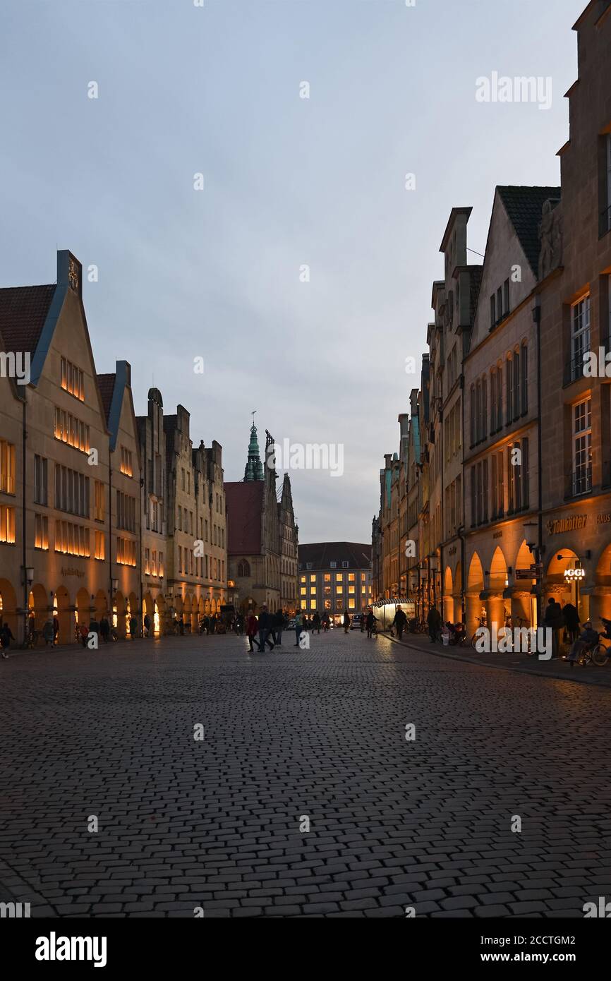 Muenster, Prinzipalmarkt al crepuscolo, ora blu, case illuminate a timpano, via dello shopping di lusso, vista sull'antica strada acciottolata, Germania, Europa. Foto Stock