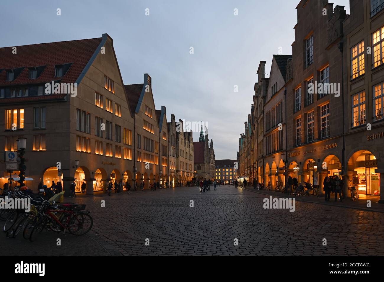 Muenster, Prinzipalmarkt al crepuscolo, ora blu, case illuminate a timpano, via dello shopping di lusso, vista sull'antica strada acciottolata, Germania, Europa. Foto Stock