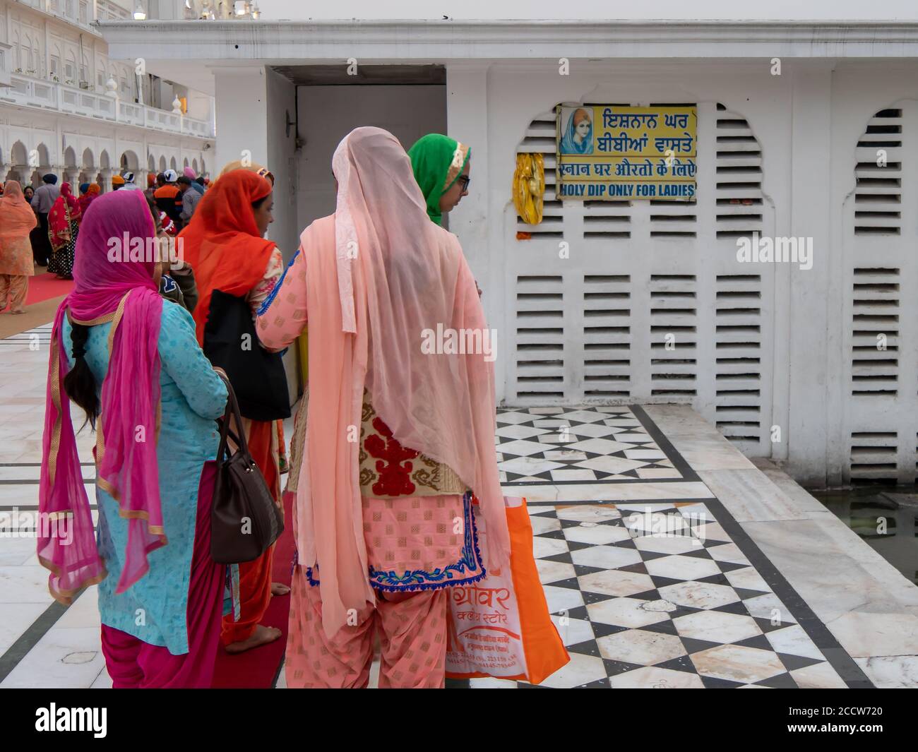 AMRITSAR, INDIA - 18 MARZO 2019: Le donne sikh accodano per tuffarsi nella piscina Santa del tempio dorato Foto Stock AMRITSAR, INDIA - 18 MARZO 2019: Le donne sikh accodano per tuffarsi nella piscina Santa del tempio dorato Foto Stock