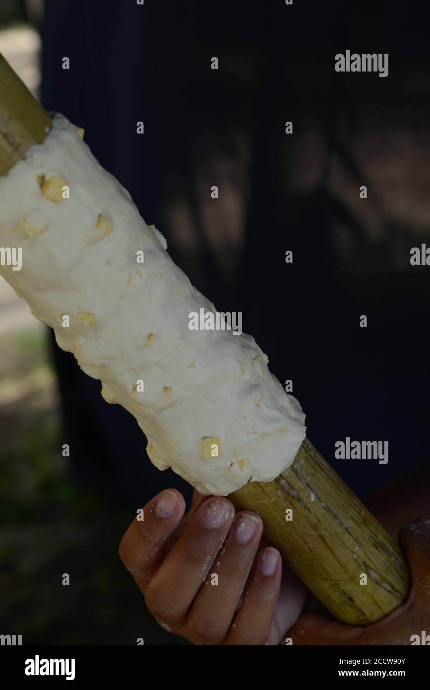 Consiste di un impasto di farina di manioca e formaggio intorno ad un palo di bambù e arrostito sulle calette. Foto Stock