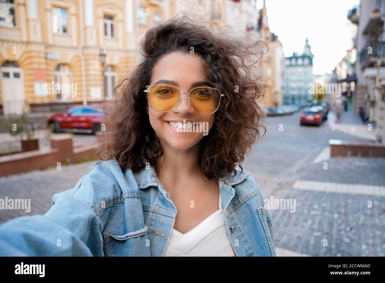 Ritratto di sorridente giovane donna ispanica che registra vlog da telefono cellulare all'aperto. Foto Stock
