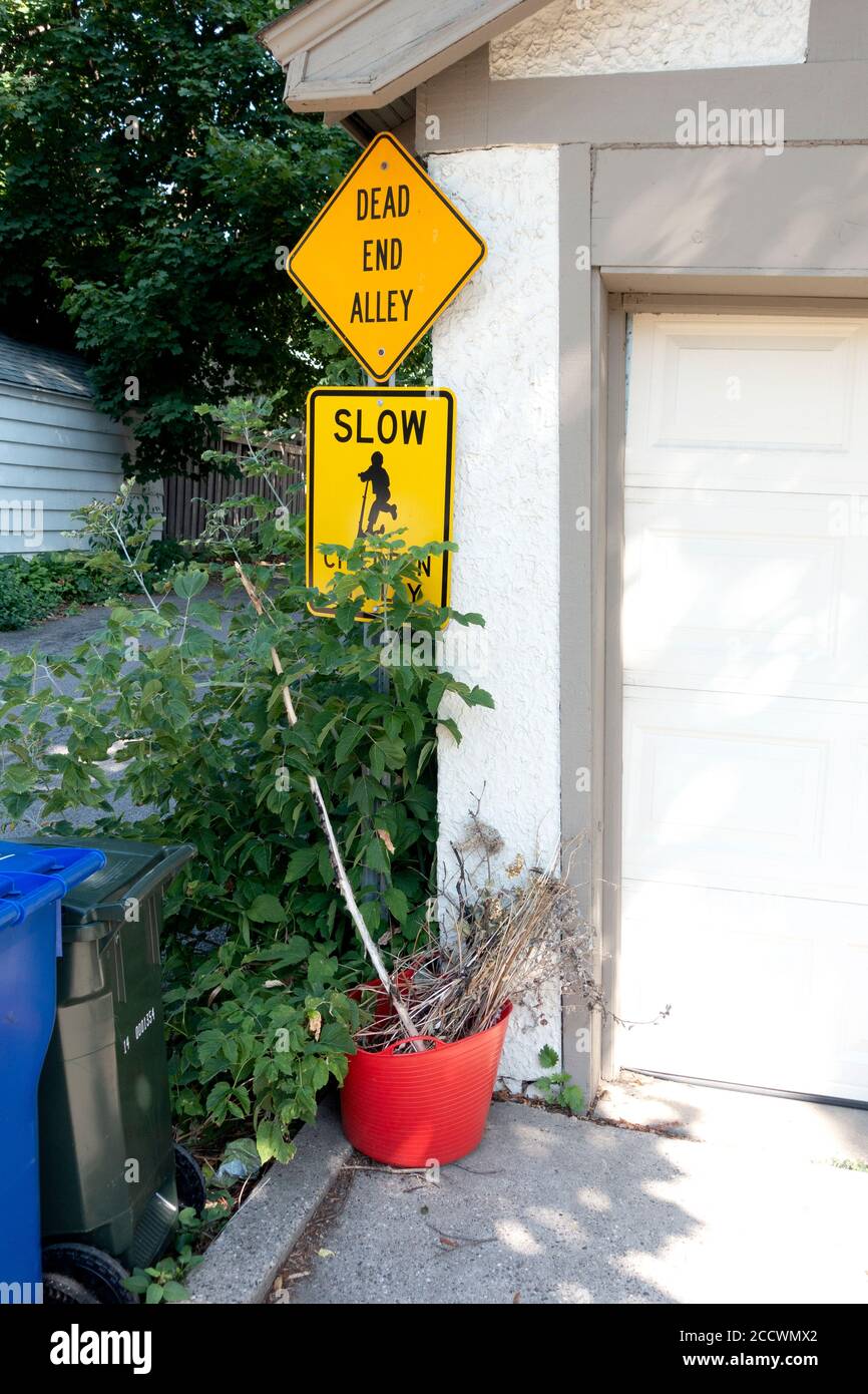 Vicolo cieco, vialetto e vaso rosso contenente una pianta morta. St Paul Minnesota, Minnesota, Stati Uniti Foto Stock