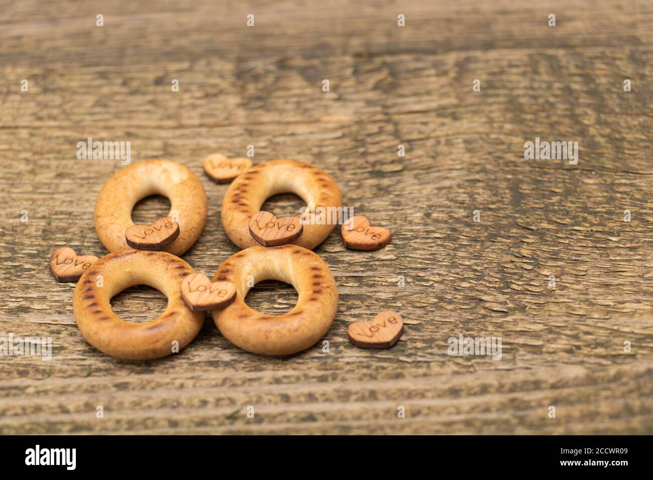 Gustosi bagel su sfondo di legno, concetto d'amore Foto Stock