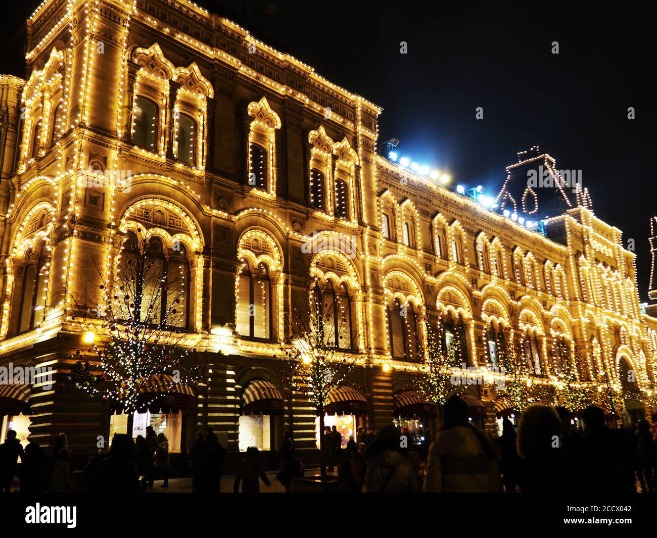 Le luci urbane della città bokeh, luminoso Christmas Street illuminazione sulla facciata degli edifici. La città è decorata per la festa di Christmastide. Nuovo Foto Stock