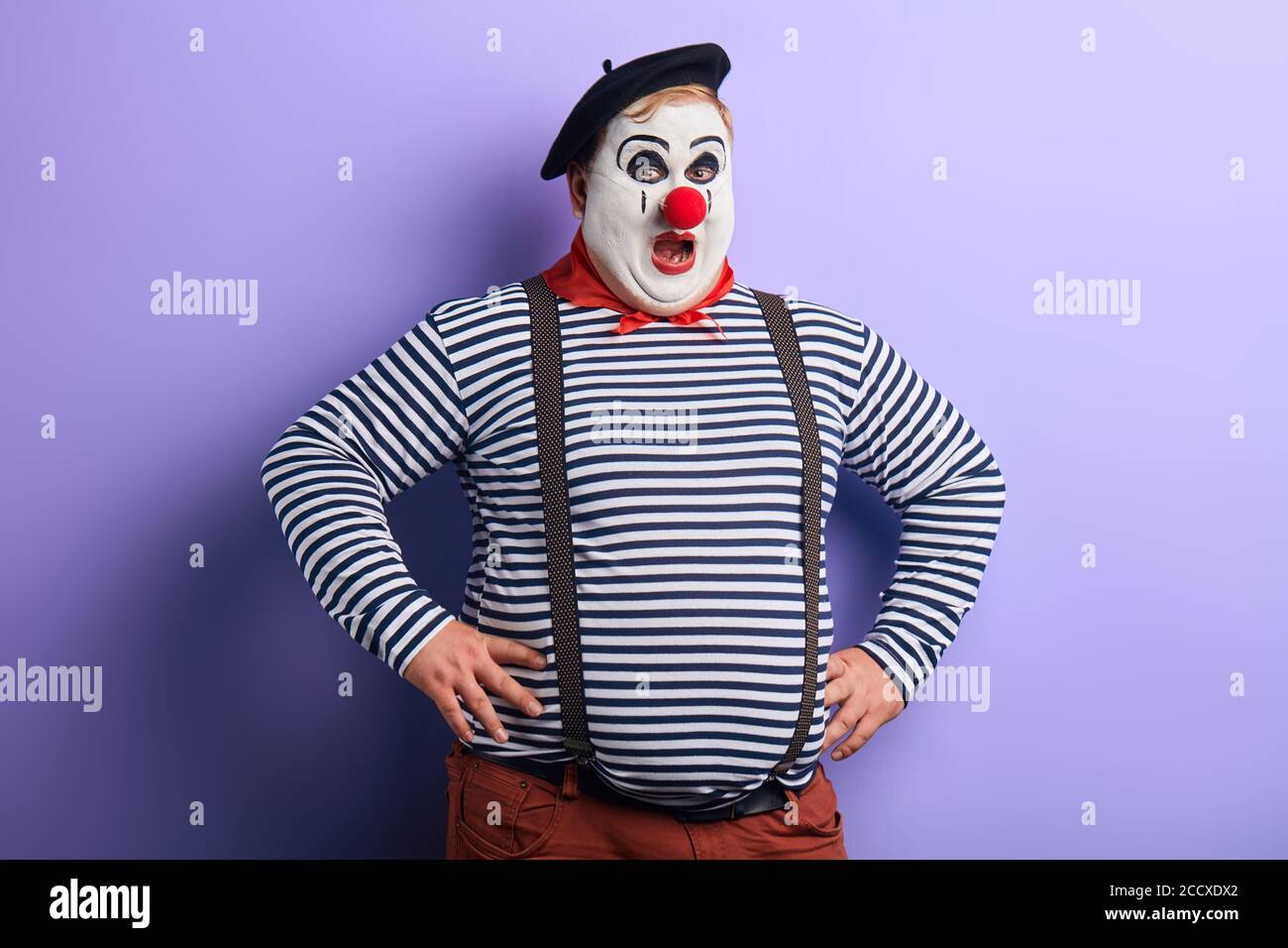 crazy mime cantare canzoni, comic performer imitare passanti. primo piano foto. isolato sfondo blu, studio di ripresa. Foto Stock