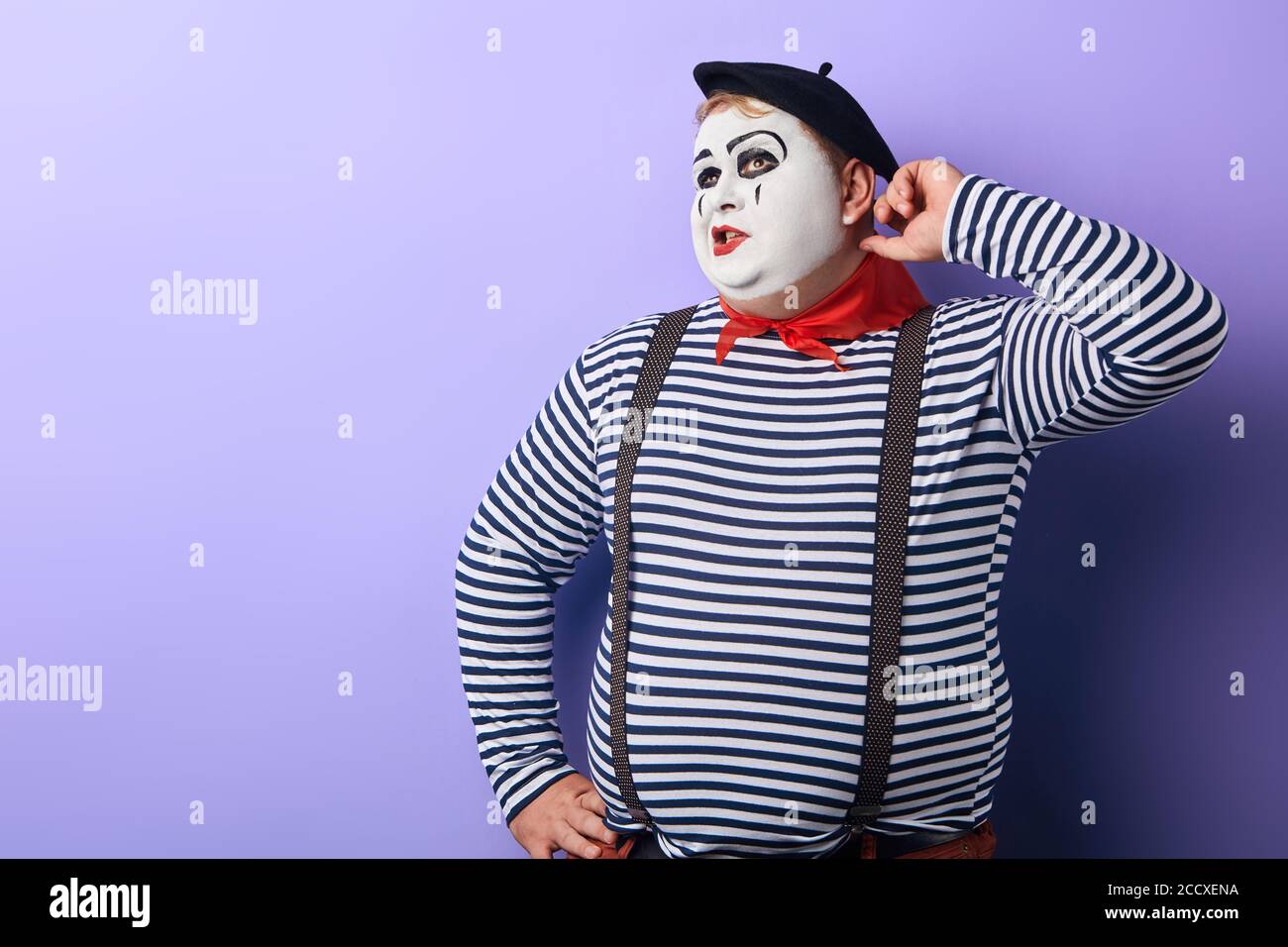 l'uomo pensivo perplesso graffiando la testa tenendo la mano sull'anca guardando in su, essendo perplesso con l'offerta. copia spazio. idea , programma Foto Stock