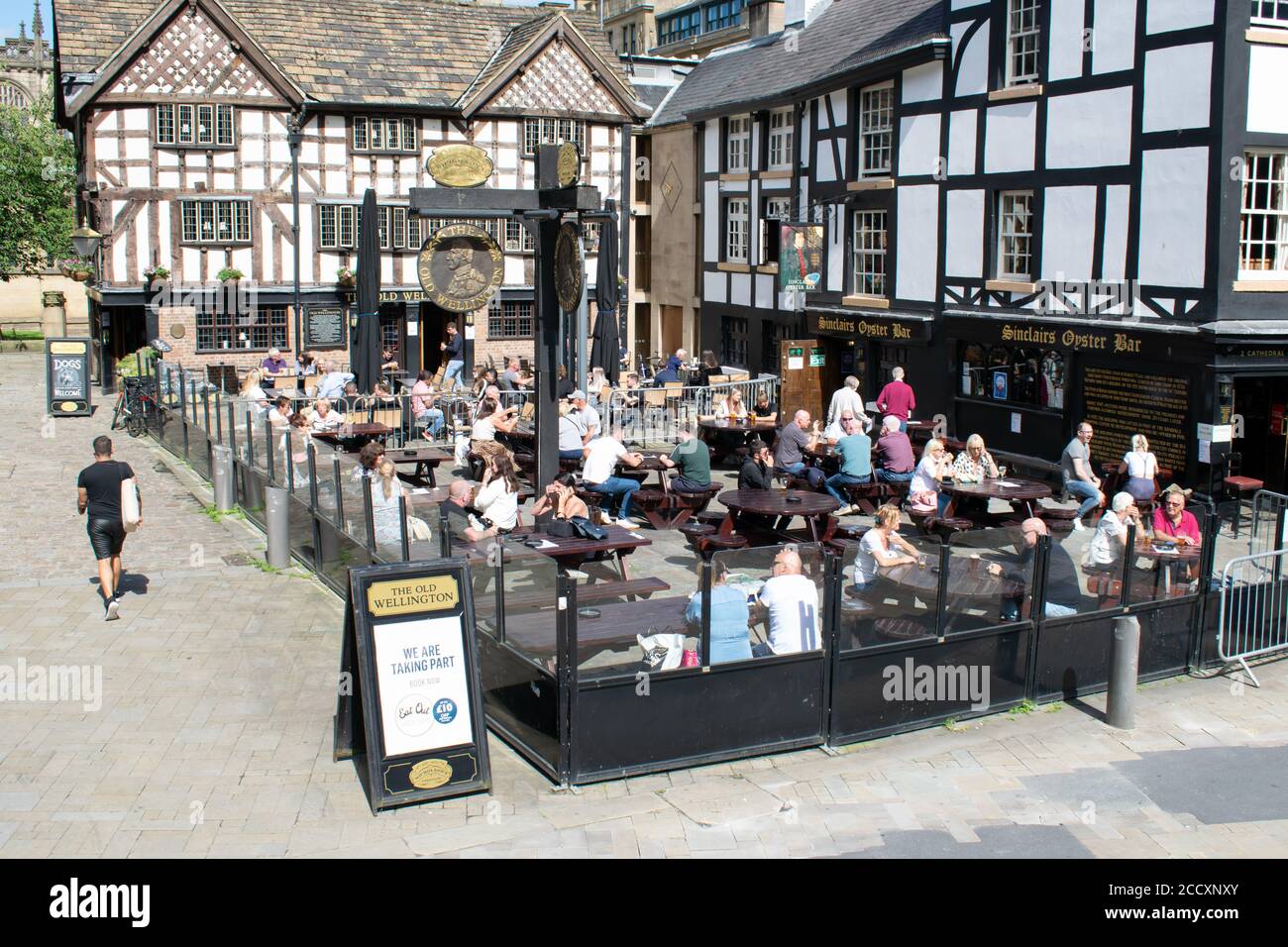 Mangiare fuori per aiutare fuori schema. Folla fuori Sinclairs Oyster bar. Tavola a sandwich con inserzione per la partecipazione al programma. Manchester Regno Unito. Foto Stock