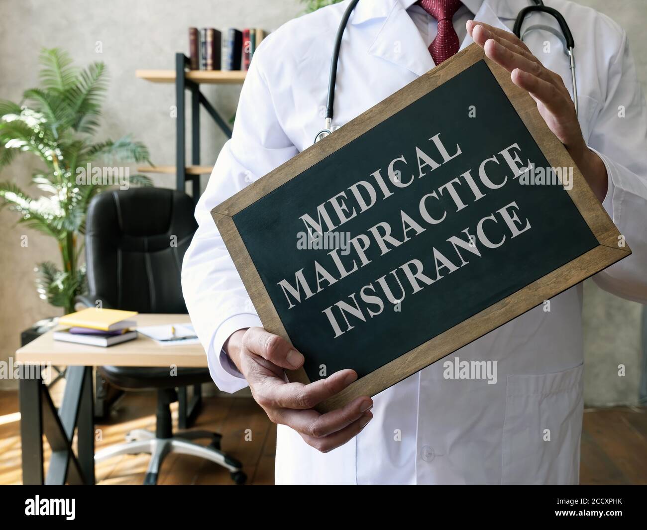 Assicurazione medica di malpratica o concetto di responsabilità professionale. Medico con lavagna. Foto Stock