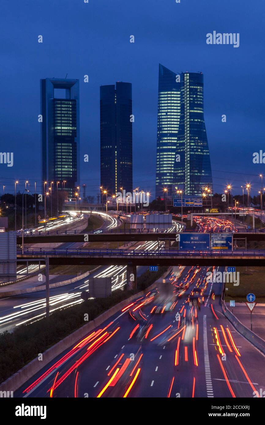 Piste leggere, traffico stradale di notte, quartiere finanziario con grattacieli, Madrid, Spagna Foto Stock