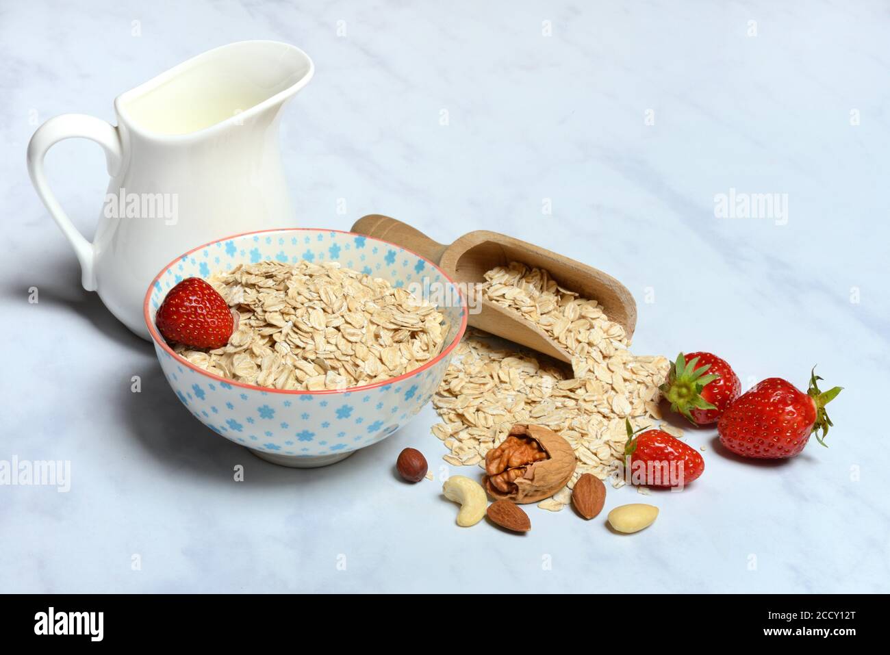 OAT si flakes in ciotola con fragole, noci e caraffa di latte, Germania Foto Stock